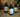 Three Lantern & Veil room sprays bottles placed on a light wood table, amber lighting, cozy home background.
