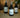Three Lantern & Veil room sprays bottles placed on a light wood table, amber lighting, cozy home background.