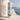 Body powder bottle with Aegean Coast design against a scenic background