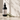 Black spray bottle labeled 'The Atrium' on a light surface with white flowers and green leaves.