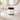 Lotion jar labeled 'Beachcomber Bliss' on a bathroom counter with a mirror and sink in the background.