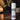 Body powder bottle labeled 'Blackwood Estate' on a wooden surface with a candle and plant in the background.