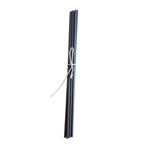 Set of gray fiber diffuser reeds tied with a white string on a white background