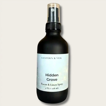 Black spray bottle labeled 'Hidden Grove' on a light gray background
