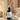 Black body fragrance spray bottle labeled 'Crimson Ember' on a neutral background