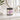 Jar of Mango Dragonfruit sugar scrub on a bathroom counter with a mirror and towel in the background.