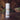 Body powder container labeled 'Sandalwood Vanilla' on a wooden surface with a blurred natural background.