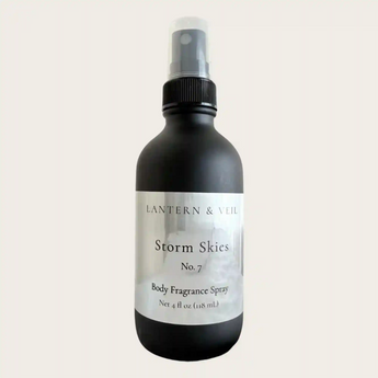 Black body fragrance spray bottle labeled 'Lantern & Veil Storm Skies No. 7' on a light gray background