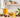 Jojoba oil in a glass bottle and bowl with jojoba seeds and green leaves on a bright, neutral workspace, styled for natural soapmaking ingredients.