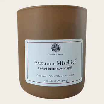 A candle in a matte brown jar with a white label reading Autumn Mischief Limited Edition Autumn 2026