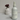 Lantern & Veil Carioca Nights fragrance mist bottle on a neutral background with a vase of flowers.