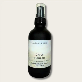 Black bottle of Citrus Horizon Room Spray on a  light brey background.