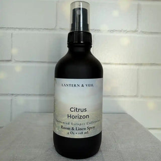 Black spray bottle labeled 'Citrus Horizon' by Lantern & Veil on a light gray surface with a white tiled wall background.