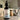 Beard conditioning oil bottle on a bathroom counter with a brush and sink in the background.