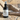 Black body fragrance spray bottle labeled 'Clear Horizon' on a textured surface.