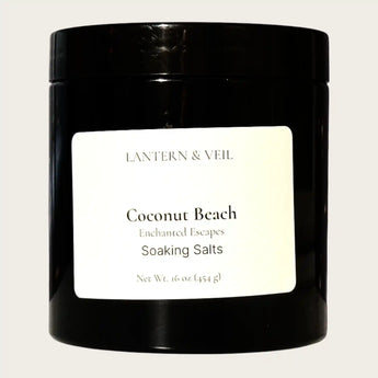 Black container of 'Coconut Beach' soaking salts by Lantern & Veil on a white background
