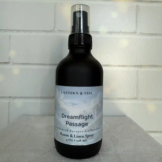 Black room and linen spray bottle labeled 'Dreamflight Passage' by Lantern & Veil on a light background.