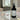 Black spray bottle labeled 'Forever Magical' on a marble surface with flowers.