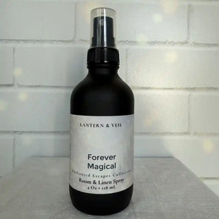 Black spray bottle labeled 'Forever Magical' by Lantern & Veil on a light surface with a tiled wall background.