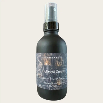 A matte black bottle of Lantern & Veil 'Hallowed Ground'  room and linen spray, shown against a solid off-white background.