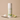 Key Lime body powder canister with vanilla bean and lime wedge on a beige background