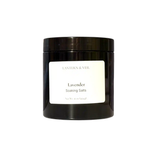 Black jar of lavender soaking salts with a white label on a white background