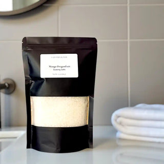Black packaging of Mango Dragonfruit Soaking Salts on a bathroom counter