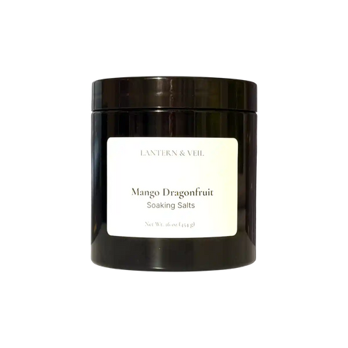 Black jar of 'Mango Dragonfruit Soaking Salts' by Lantern & Veil on a white background