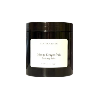 Black jar of 'Mango Dragonfruit Soaking Salts' by Lantern & Veil on a white background
