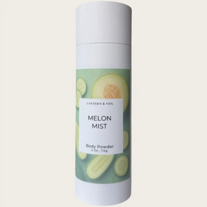 Body powder canister labeled 'Melon Mist' with a green label on a light beige background