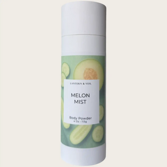 Body powder canister labeled 'Melon Mist' with a green label on a light beige background