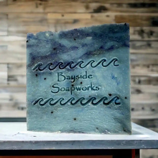 Midnight Cypress Soap Bar on a counter with a wood panel wall background