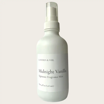White bottle of 'Midnight Vanilla' fragrance mist with a label on a light gray background