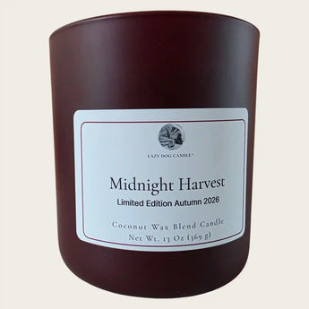 A candle in a matte wine jar with a white label reading 'Midnight Harvest'  shown on a light beige background.