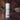 Body powder container labeled 'Sandalwood Vanilla' on a wooden surface with a blurred natural background.
