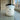 Candle labeled 'Sunlit Mango' on a speckled countertop with a window in the background