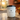 Candle labeled 'Sunlit Mango' on a kitchen counter with a warm glow