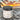 Cleansing sugar scrub jar labeled 'Sunset Colada' with a beach sunset background
