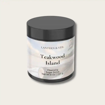 Cleansing sugar scrub container labeled 'Teakwood Island' by Lantern & Veil on a light gray background.