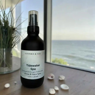 Bottle of Tidewater Spa room and linen spray on a table with a scenic spa like background