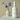 White bottle of 'Twilight Grove' fragrance mist with a vase of blue flowers on a beige background