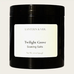 Black container of 'Twilight Grove' soaking salts by Lantern & Veil on a beige background