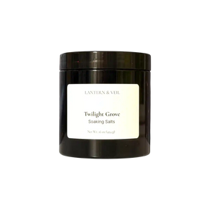 Black container of 'Twilight Grove' soaking salts with a white label on a white background