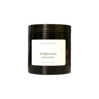 Black container of 'Twilight Grove' soaking salts with a white label on a white background