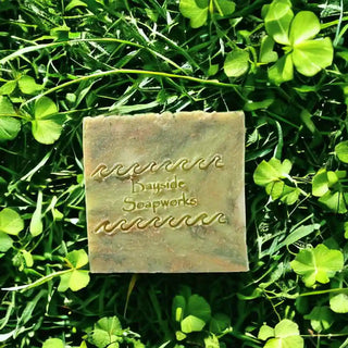 Verdant Retreat Soap Bar lying on grass and green clover