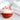 Red and white bath bomb on a marble surface with towels in the background