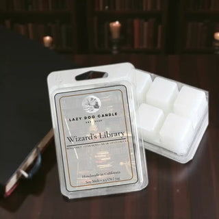 Wizard’s Library soy wax melt displayed on a wooden desk in a dimly lit library with bookshelves and candlelight