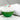 Green and white bath bomb with red and green accents on a marble surface.